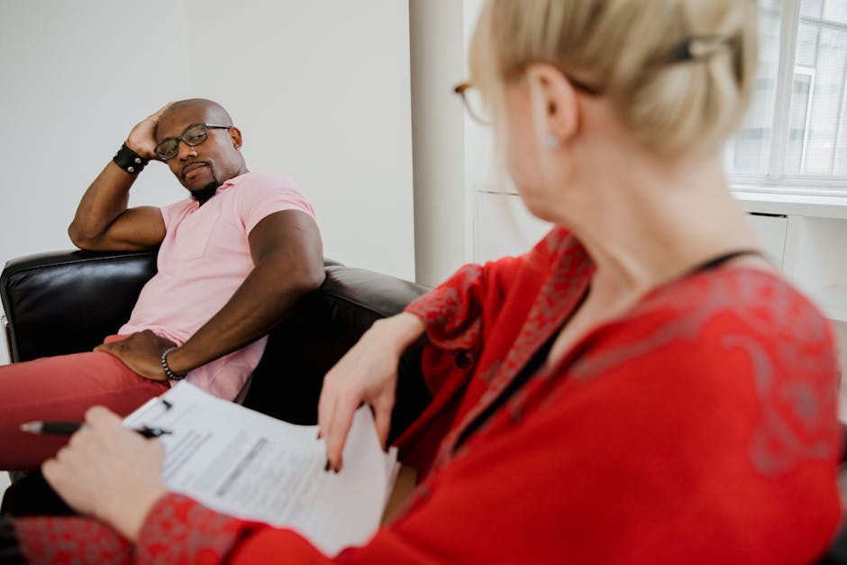 Black man and Caucasian woman in therapy session discussing mental health.