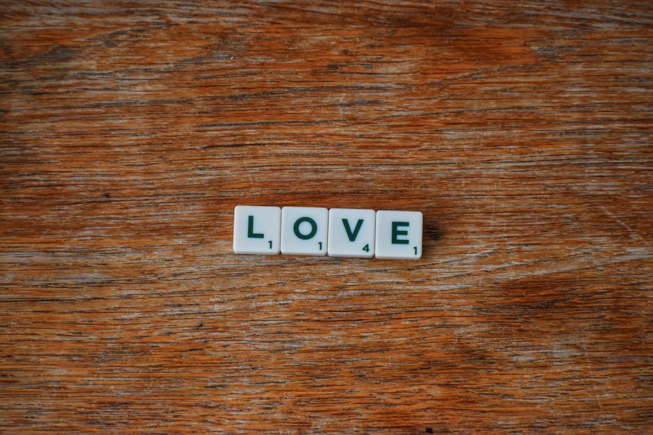 Scrabble tiles spell 'LOVE' on a rustic wooden surface, conveying a warm and heartfelt message.