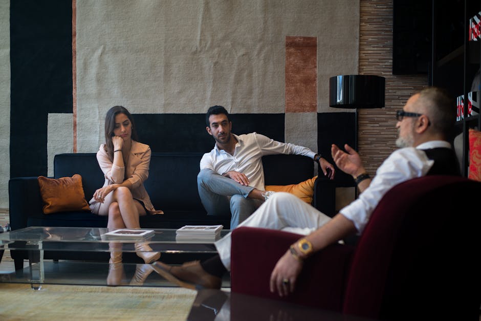 Three adults engaged in a thoughtful therapy session in a stylish Genoa interior.