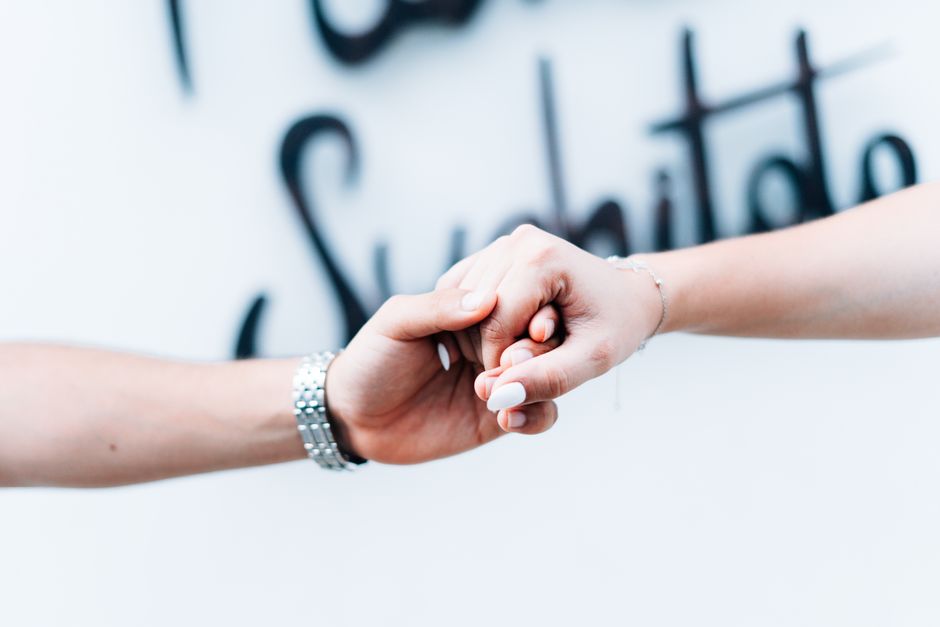 A tender close-up of a couple holding hands with a soft focus background, symbolizing love and unity.