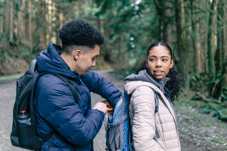 A young couple enjoys a leisurely hike in a forest, showcasing their outdoor spirit.